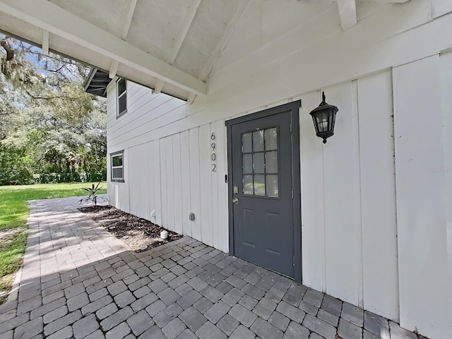 doorway to property with a yard and a patio