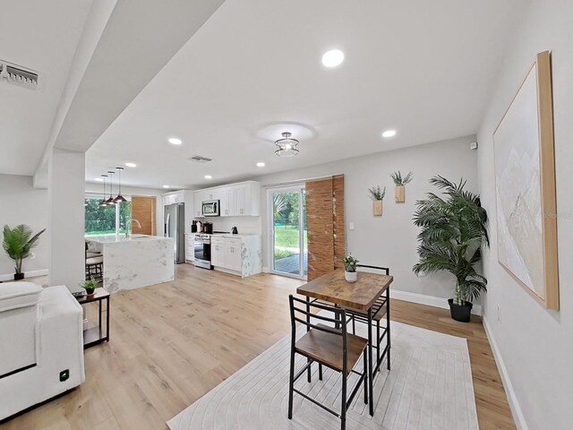 dining space featuring sink and light wood-type flooring