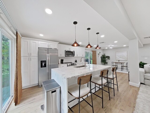 kitchen with white cabinets, a healthy amount of sunlight, sink, and appliances with stainless steel finishes