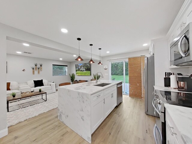 kitchen featuring sink, stainless steel appliances, light hardwood / wood-style floors, a kitchen island with sink, and white cabinets