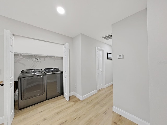 washroom featuring light hardwood / wood-style floors and separate washer and dryer