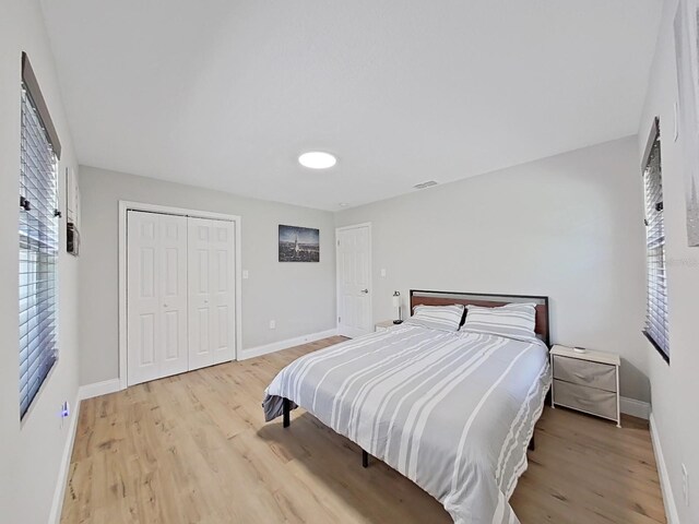 bedroom with light wood-type flooring and a closet