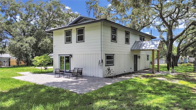 rear view of house with a patio area and a lawn