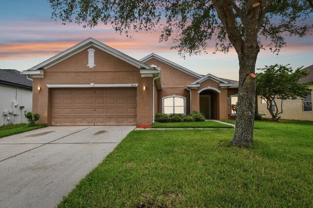 single story home with a yard and a garage