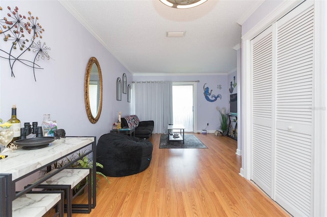 living room with light wood-type flooring and ornamental molding