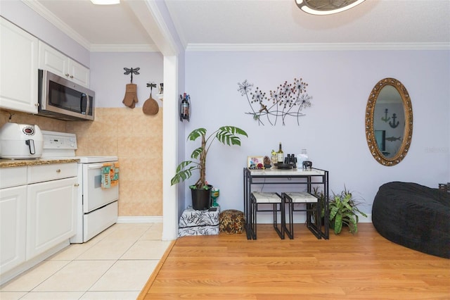 kitchen featuring ornamental molding, white cabinets, white electric range oven, and light tile patterned floors