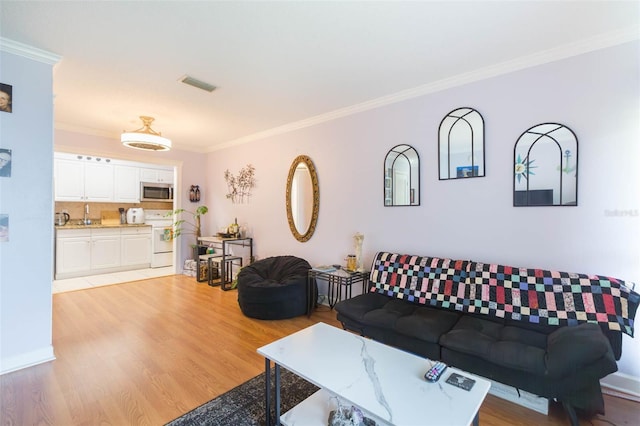 living room featuring ornamental molding and light hardwood / wood-style flooring