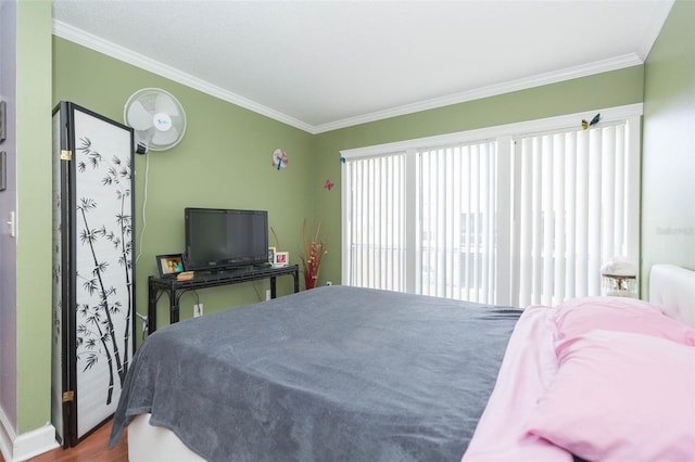 bedroom with multiple windows, crown molding, and hardwood / wood-style floors