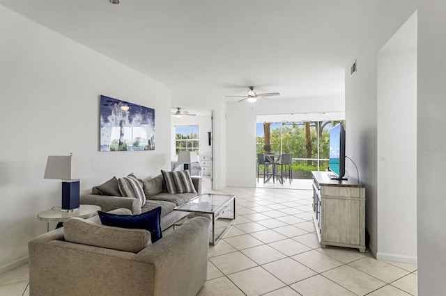 living room with ceiling fan, a wealth of natural light, and light tile patterned floors