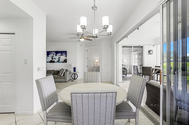 tiled dining area featuring ceiling fan with notable chandelier