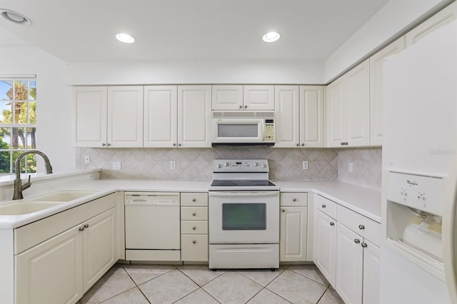 kitchen featuring light tile patterned flooring, sink, white cabinetry, tasteful backsplash, and white appliances