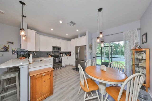 dining room featuring sink, beverage cooler, and light hardwood / wood-style floors