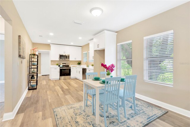 dining space with light hardwood / wood-style floors