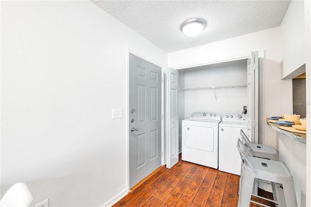 laundry room with washing machine and clothes dryer, laundry area, a textured ceiling, and dark wood-style flooring