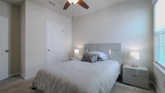 carpeted bedroom featuring multiple windows and ceiling fan