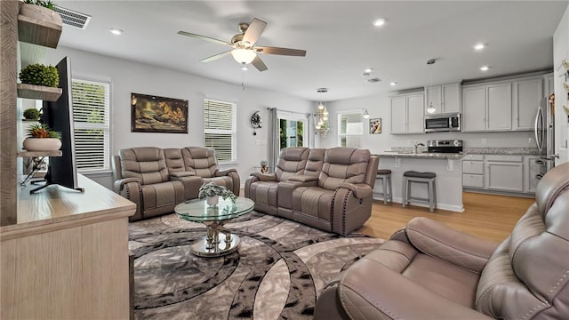 living room featuring ceiling fan and light hardwood / wood-style floors