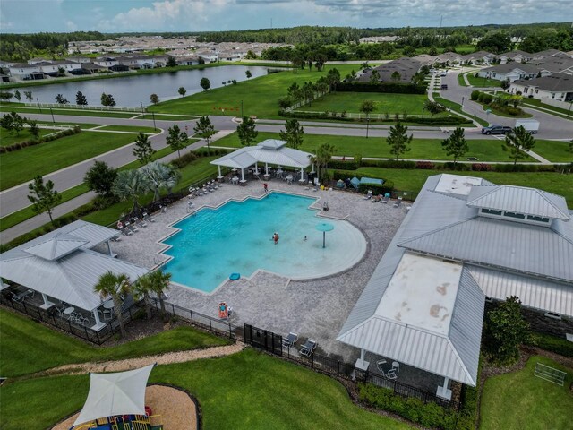 view of swimming pool featuring a water view, a patio, and a lawn