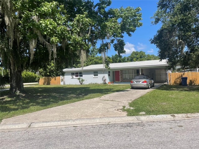 ranch-style home with a carport and a front yard