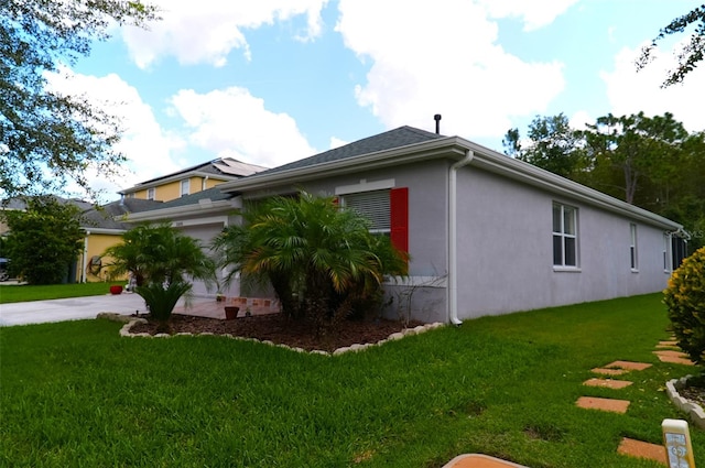 view of side of home with a garage and a lawn