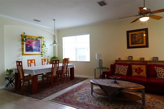 tiled living room with ceiling fan and crown molding