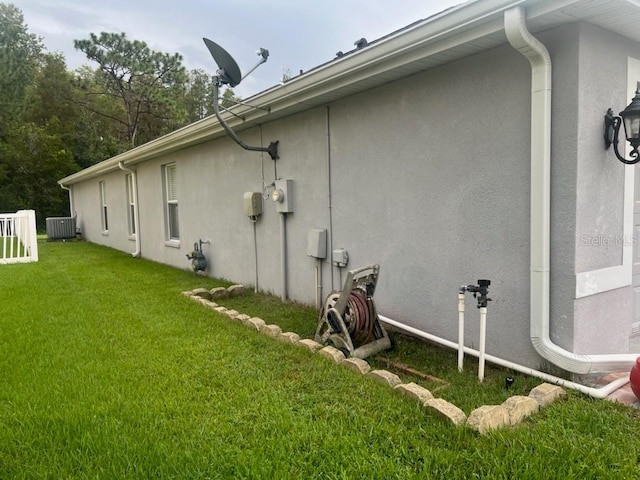 view of property exterior featuring a yard and central air condition unit