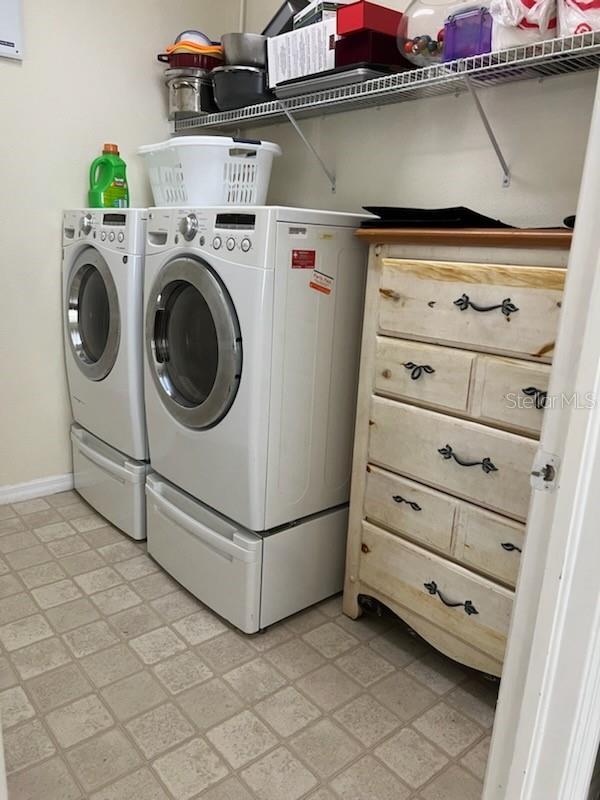 laundry room with washing machine and dryer and light tile patterned floors