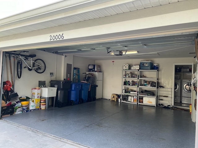 garage with a garage door opener, independent washer and dryer, and white fridge