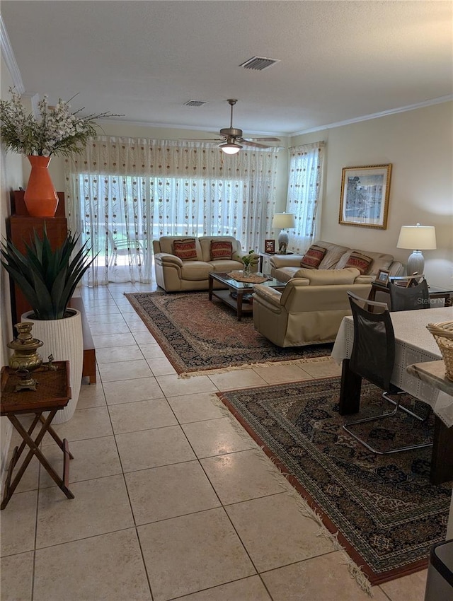 tiled living room with crown molding and ceiling fan