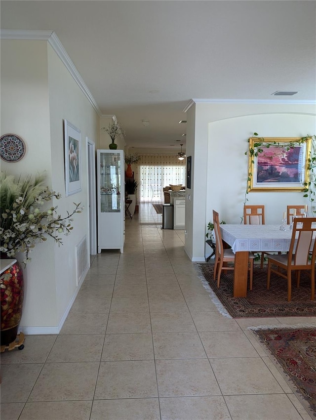 hall with crown molding and light tile patterned flooring