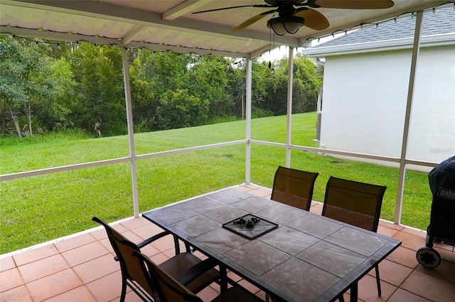 unfurnished sunroom featuring ceiling fan