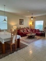 living room featuring ceiling fan and tile patterned flooring