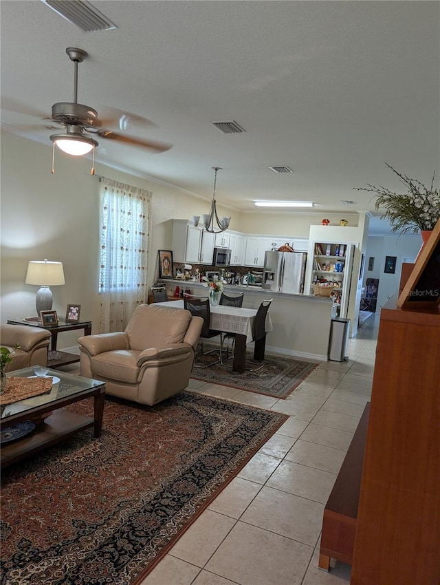 tiled living room featuring ceiling fan and a textured ceiling