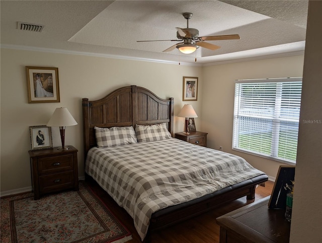 bedroom with ceiling fan, ornamental molding, and a textured ceiling