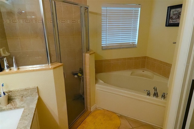 bathroom featuring independent shower and bath, vanity, and tile patterned flooring