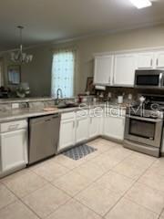 kitchen with appliances with stainless steel finishes, sink, and white cabinets