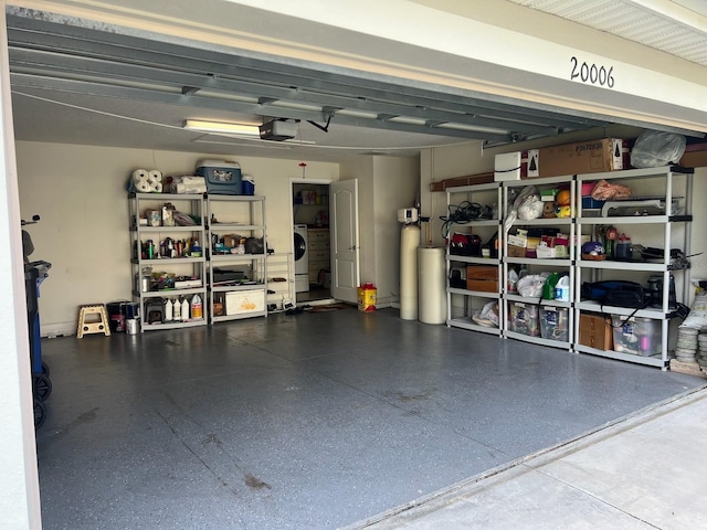 garage with a garage door opener and washer / dryer