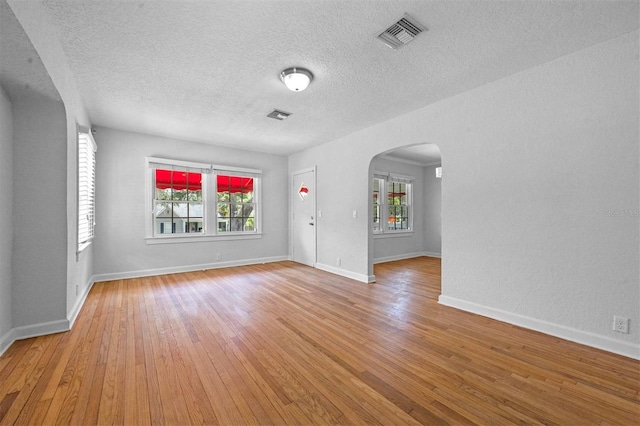 unfurnished room featuring hardwood / wood-style flooring and a textured ceiling