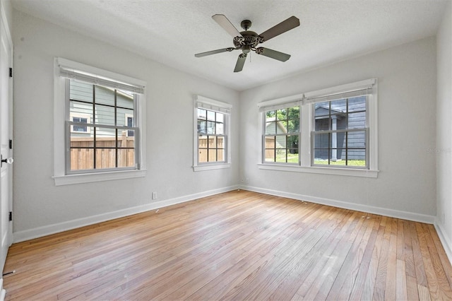 empty room with a textured ceiling, ceiling fan, and light hardwood / wood-style flooring