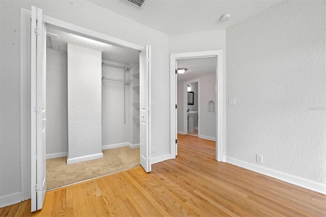 unfurnished bedroom featuring wood-type flooring and a closet