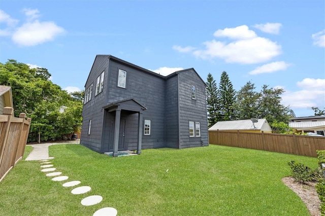 back of house with a lawn