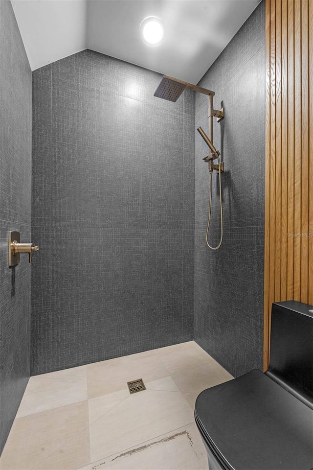 bathroom featuring tiled shower and toilet