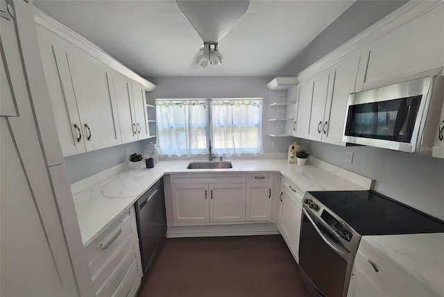 kitchen with stainless steel appliances, white cabinetry, sink, and light stone counters