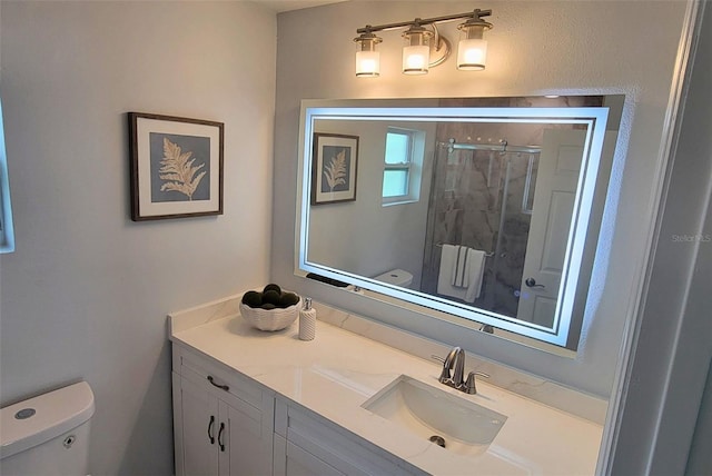 bathroom with vanity, a shower with shower door, and toilet