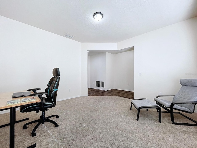 carpeted office space with a textured ceiling