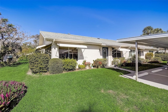 rear view of property with a yard and stucco siding