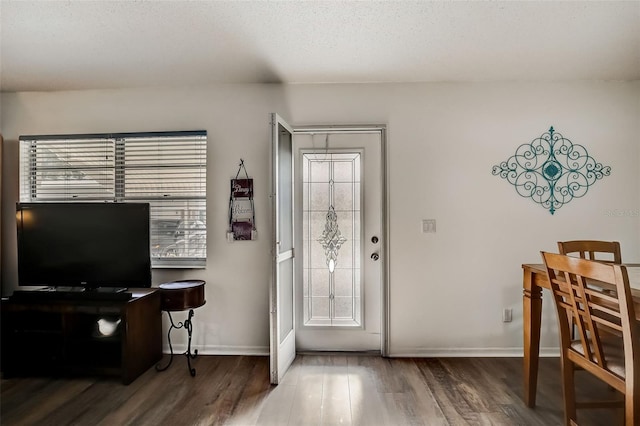 entryway featuring a textured ceiling, wood finished floors, and baseboards