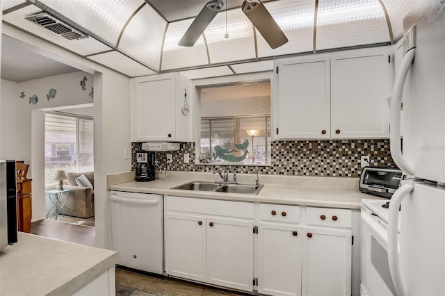 kitchen with white appliances, light countertops, a sink, and white cabinetry