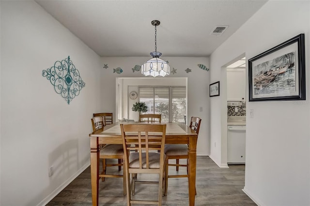 dining room featuring visible vents, dark wood finished floors, and baseboards