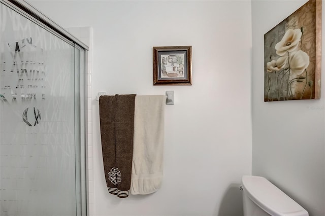 bathroom featuring toilet and an enclosed shower