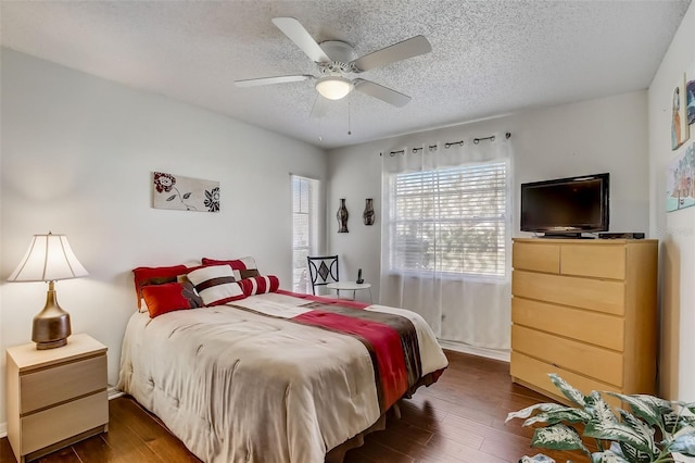 bedroom with dark wood-type flooring, a textured ceiling, and ceiling fan